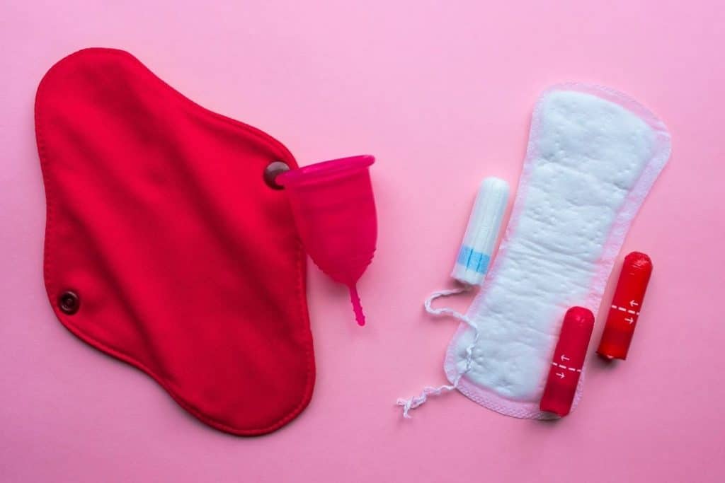 Red reusable period pads with a period cup and tampons